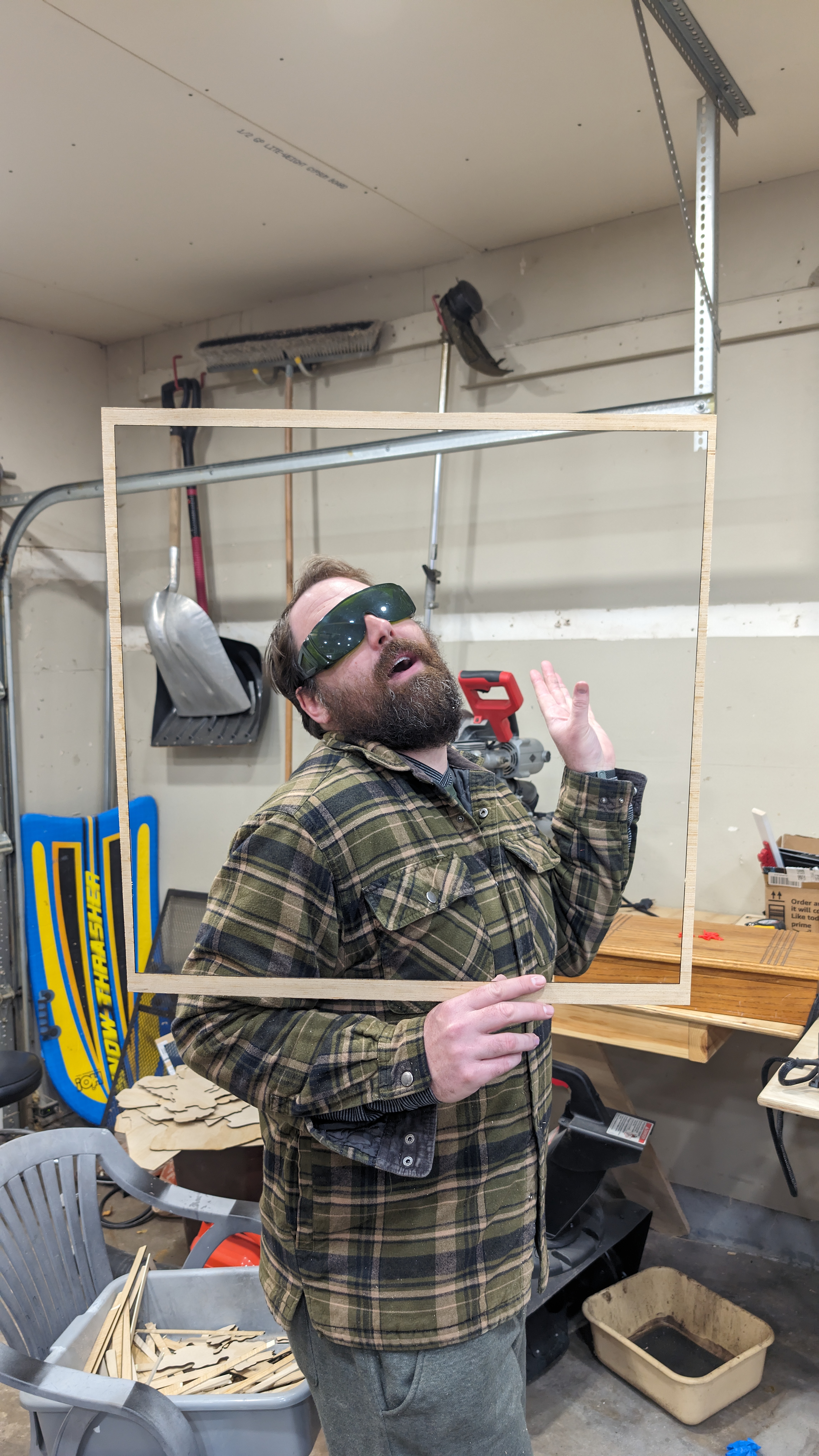 Nick holding a rectangular wood frame in the workshop