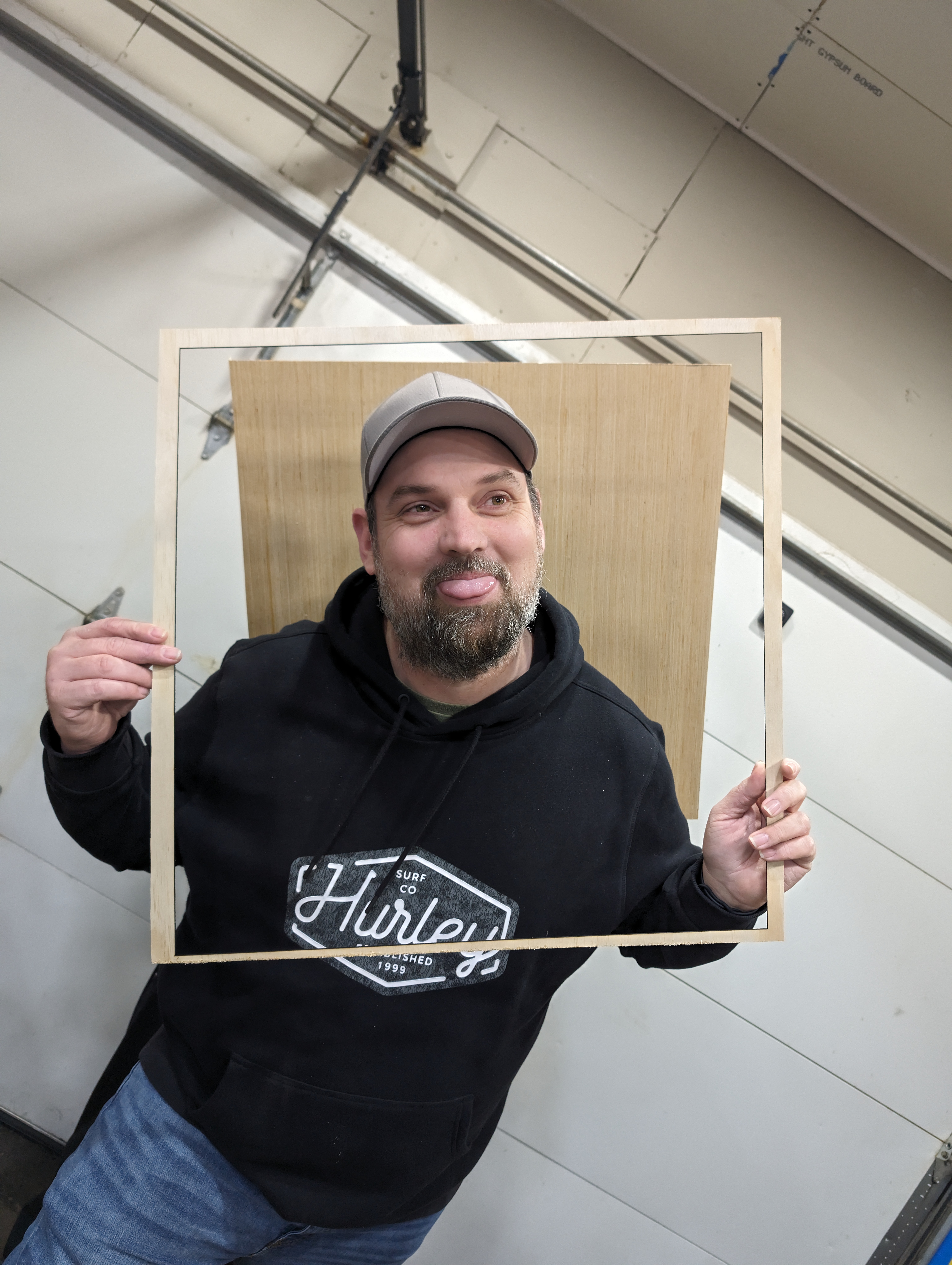 James holding a wood frame in the workshop